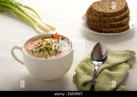 Bowl of chicken soup with vegetables, noodles and bread Stock Photo
