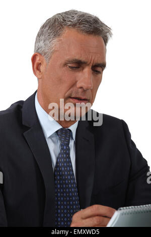 A portrait of a mature businessman taking notes. Stock Photo