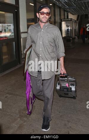 A dishevelled Luke Perry sporting a scruffy stubble arrives in Los Angeles at LAX carrying a framed picture under his arm  Featuring: Luke Perry Where: Los Angeles, California, United States When: 19 Oct 2014 Stock Photo