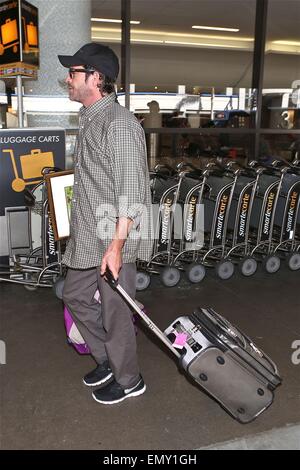 A dishevelled Luke Perry sporting a scruffy stubble arrives in Los Angeles at LAX carrying a framed picture under his arm  Featuring: Luke Perry Where: Los Angeles, California, United States When: 19 Oct 2014 Stock Photo