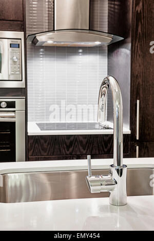 Elegant faucet and sink in island counter of modern kitchen Stock Photo