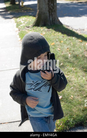 Five year old boy speaks into a two way radio / walkie talkie Stock Photo