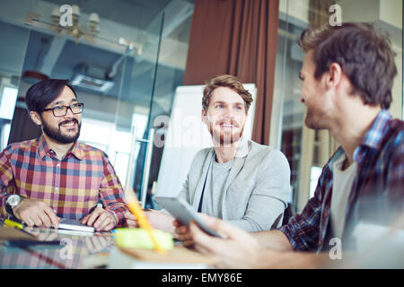 Three successful managers interacting in office Stock Photo