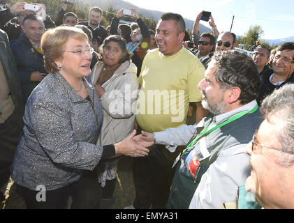 Llanquihue, Chile. 23rd Apr, 2015. Image provided by Chile's Presidency shows Chilean President Michelle Bachelet (L front) inspecting an area affected by the eruption of the Calbuco volcano, in Lago Chapo, Llanquihue province, Chile, on April 23, 2015. At least 4,150 people have been evacuated from the proximities of Calbuco volcano, after it began to erupt violently on Wednesday afternoon in the south of Chile and throwing a huge plume of ash and pyroclastic material. © Chile's Presidency/Xinhua/Alamy Live News Stock Photo