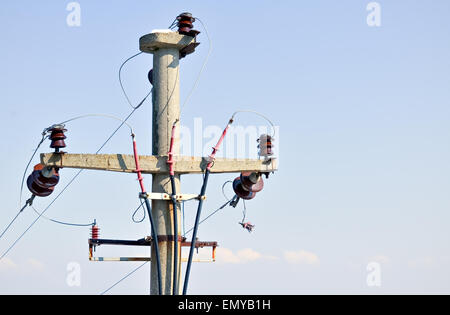Closeup of simple three-phase electric pole with the sky in background Stock Photo