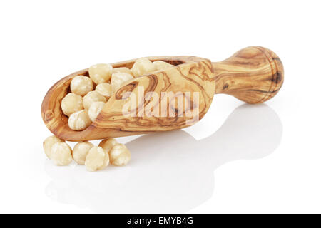 peeled and cleaned hazelnut kernels in wood scoop, isolated Stock Photo