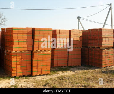 stacks of red bricks for the construction on the construction site outside Stock Photo