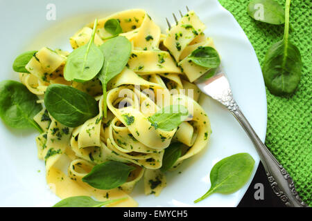 Tagliatelle pasta with spinach sauce and fresh leafs on a white plate Stock Photo