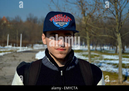 Closeup portrait of a handsome young caucasian man with cap in a park Stock Photo