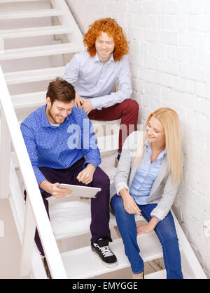 team with tablet pc computer sitting on staircase Stock Photo