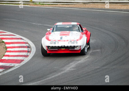 Image shows a single isolated red and white historic sports car on a race track. Stock Photo