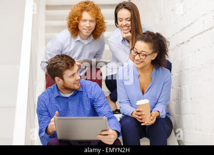 team with laptop and tablet pc on staircase Stock Photo