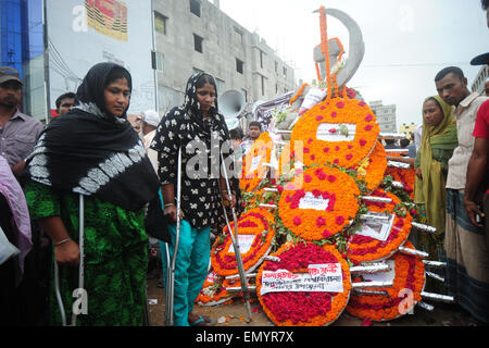 Dhaka, Bangladesh. 24th Apr, 2015. Bangladeshi people lay floral wreaths in memory of the victims of Rana Plaza building collapse as they mark the second anniversary of the disaster at the site where the building once stood in Savar, on the outskirts of Dhaka on April 24, 2015. Demonstrators, including hundreds of survivors cried for compensation and demanded safety and labour rights in thousands of garment factories. Credit:  Mamunur Rashid/Alamy Live News Stock Photo