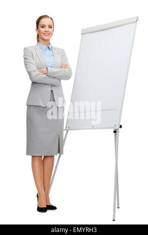 smiling businesswoman standing next to flipboard Stock Photo