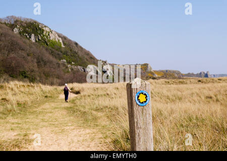 Wales Coast Path sign with a walker in Oxwich National Nature Reserve on Gower Peninsula Nicholaston Swansea Wales UK Britain Stock Photo