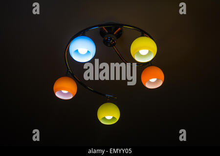 Colored lamps burning bulbs on a ceiling with reflections Stock Photo