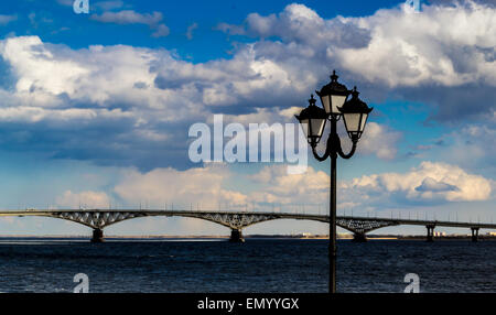 A single cast iron lampost with a large bridge in the background Stock Photo