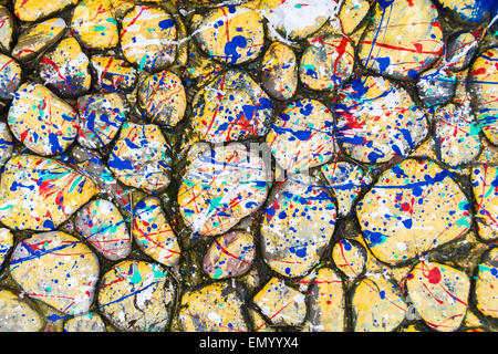 Stones covered in paint drops and drips creating a distinctive splatter pattern Stock Photo