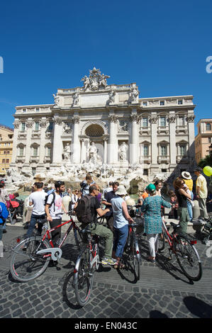 ROME, ITALY - MAY, 2013: A group of tourists on bicycles join the sightseeing crowds at the famous Trevi Fountain. Stock Photo