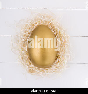 Golden Easter egg in nest Stock Photo