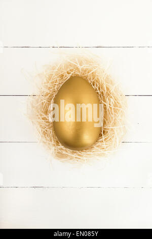 Golden Easter egg in nest Stock Photo