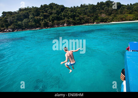 young man jumping to the sea from yacht near the beach of paradise island Stock Photo