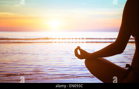 meditation concept, yoga practice on the beach at sunset Stock Photo