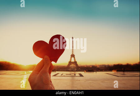 beautiful vintage card from Paris, Eiffel tower and hand with paper heart at sunrise Stock Photo