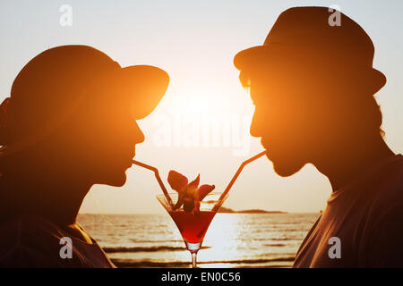 party time, couple drinking cocktail together on the beach during their honeymoon Stock Photo