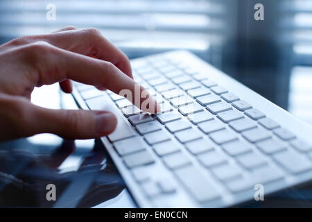 working on computer, close up of hand on keyboard Stock Photo