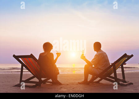 family enjoying romantic sunset on the beach Stock Photo
