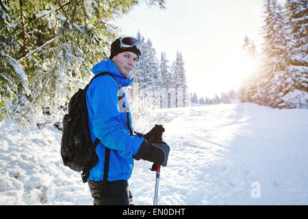 portrait of young handsome skier in winter forest Stock Photo