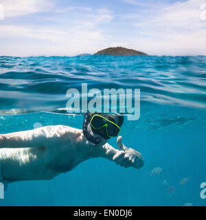 young man snorkeling, underwater split photo Stock Photo