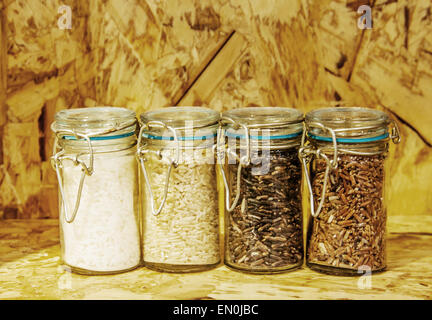 foure race of rice varieties in glass: brown rice, mixed wild rice,jasmine rice,rice burry on wood shelf Stock Photo