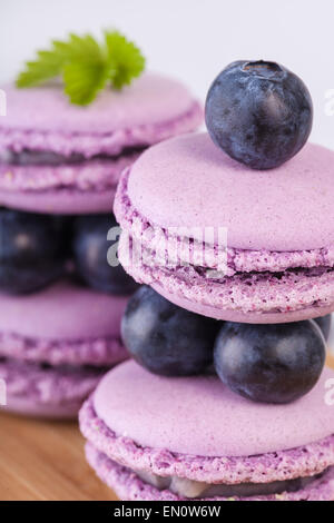 Traditional french macaroons with blueberries on the table Stock Photo