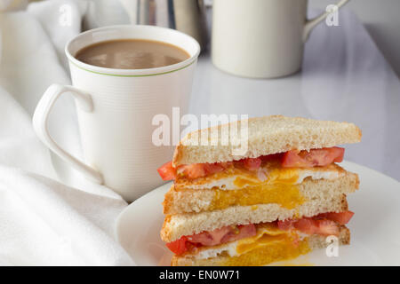 Sandwich with fried egg and tomatoes and cup of coffee selective focus horizontal Stock Photo