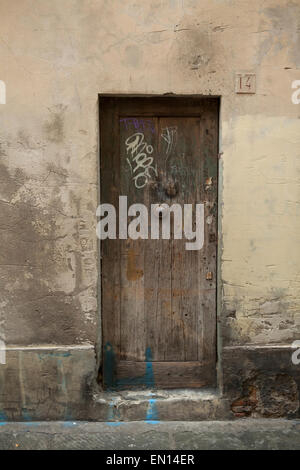 A very old door covered in graffiti and tagged in Florence, Italy Stock Photo