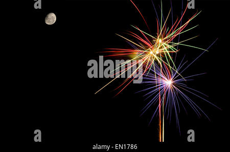 Colorful fireworks against black sky background and moon Stock Photo