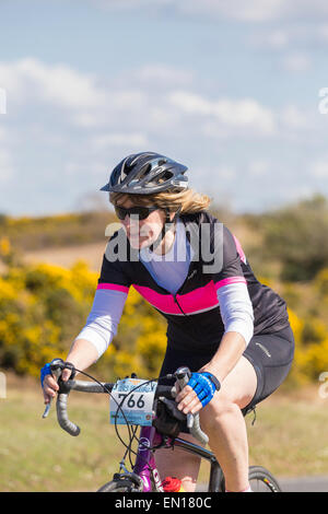 A middle-aged female cyclist competes in the New Forest Wiggle Sportive event on a sunny Sunday in Spring Stock Photo