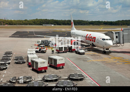 Boeing 737-900ER Air-side, airport servicing, staff loading passengers luggage into a plane hold using a conveyor belt Stock Photo