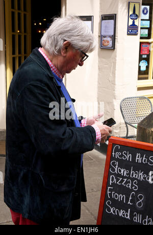 Mature Man Checking Email on Smartphone Cirencester Gloucestershire England UK Stock Photo