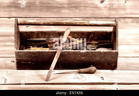 Vintage concept of an old tool box filled with tools on rustic wooden boards Stock Photo