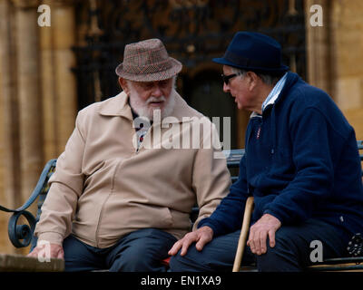 Two old men sat on a public bench chatting, Sherborne, UK Stock Photo