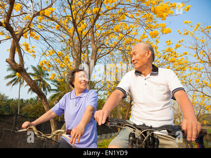 happy  senior couple riding bicycle  in the park Stock Photo