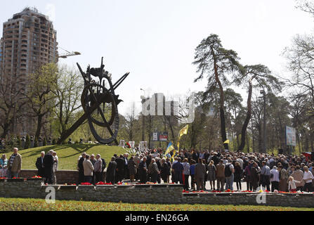 Kiev, Ukraine. 26th Apr, 2015. Ukrainians attend a memorial ceremony, near of the monument to people who were killed during cleaning works after the Chernobyl nuclear power plant disaster, in Kiev, Ukraine, 26 April 2015. On 26 April 1986 the No 4 reactor at the Chernobyl power station blew apart. Facing nuclear disaster on unprecedented scale Soviet authorities tried to contain the situation by sending thousands of ill-equipped men into a radioactive maelstrom. The men barely lasted more than a few weeks suffering lingering painful deaths. Ukrainians mark the 29 anniversary of Chernobyl's t Stock Photo