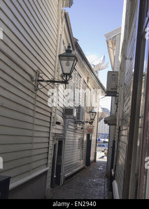 Narrow street or alley in the center of Stavanger Norway, old white wooden paneled houses, typical local architecture Stock Photo