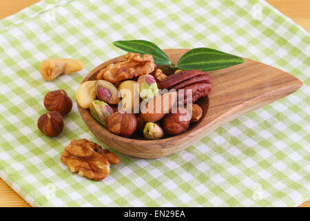 Selection of nuts in bamboo bowl on checkered cloth Stock Photo