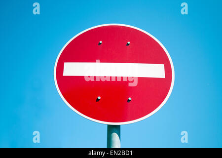 Red and white no entry road sign against blue sky Stock Photo