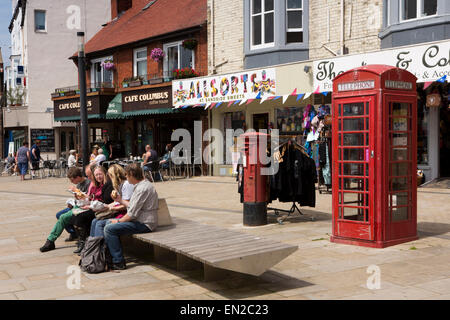 UK, England, Yorkshire, Scarborough, Sandside, visitors eating in sun on seafront bench Stock Photo