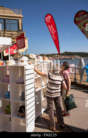 UK, England, Yorkshire, Scarborough, two middle aged women looking at hats outside beach supplies shop Stock Photo